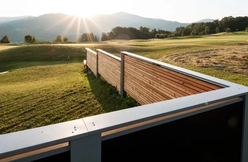 Bright Fence solar fence with wooden cladding in hilly countryside