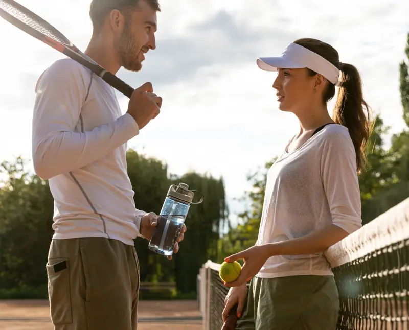 Two tennis players chatting at the net